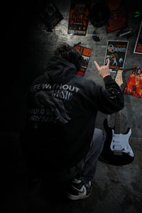 Vintage washed black streetwear hoodie with life without music would be a mistake back graphic and artistic figure print shown in a music inspired lifestyle setting.
