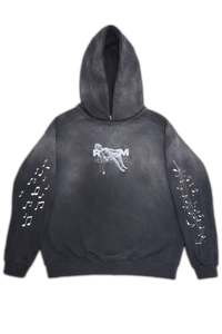 Vintage washed black streetwear hoodie with minimal chest graphic and music note sleeve prints shown on a clean studio background.