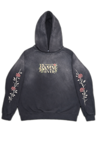 Vintage washed black streetwear hoodie with minimal chest logo and floral sleeve prints on a clean studio background.