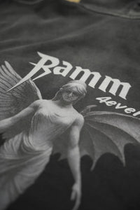 Vintage washed black streetwear hoodie with angel figure graphic print detail and minimalist logo design shown in a close-up view.