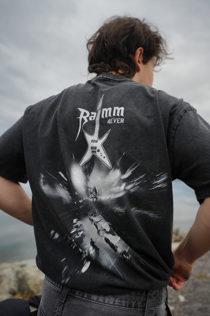 Iron Stage t-shirt in washed black streetwear style with a bold back print, worn outdoors.