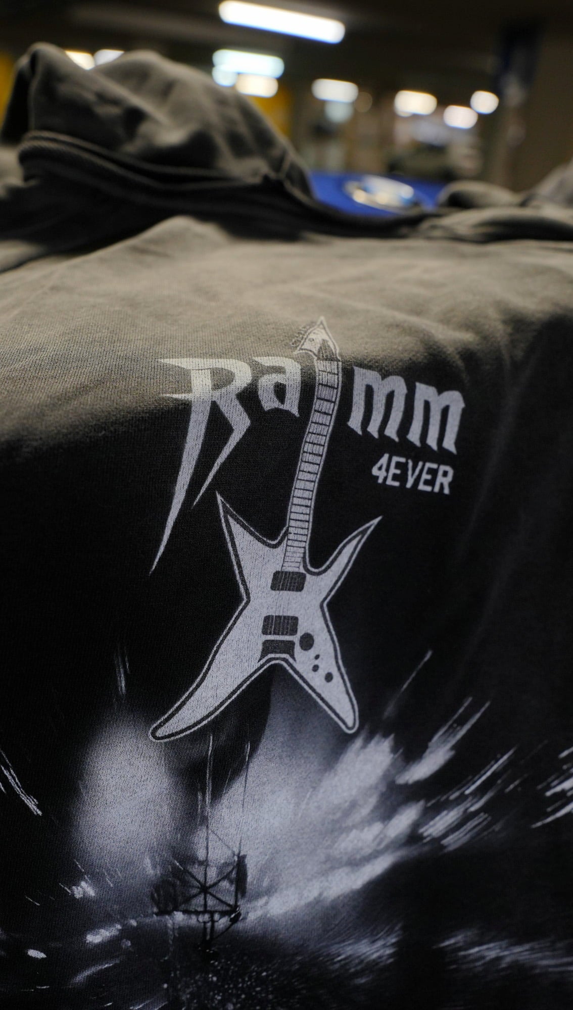 Vintage washed black streetwear hoodie with RAMM4EVER logo and electric guitar graphic print shown in a close-up detail.