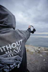 Vintage washed black streetwear hoodie with life without music would be a mistake graphic and artistic figure print shown in an outdoor lifestyle setting.